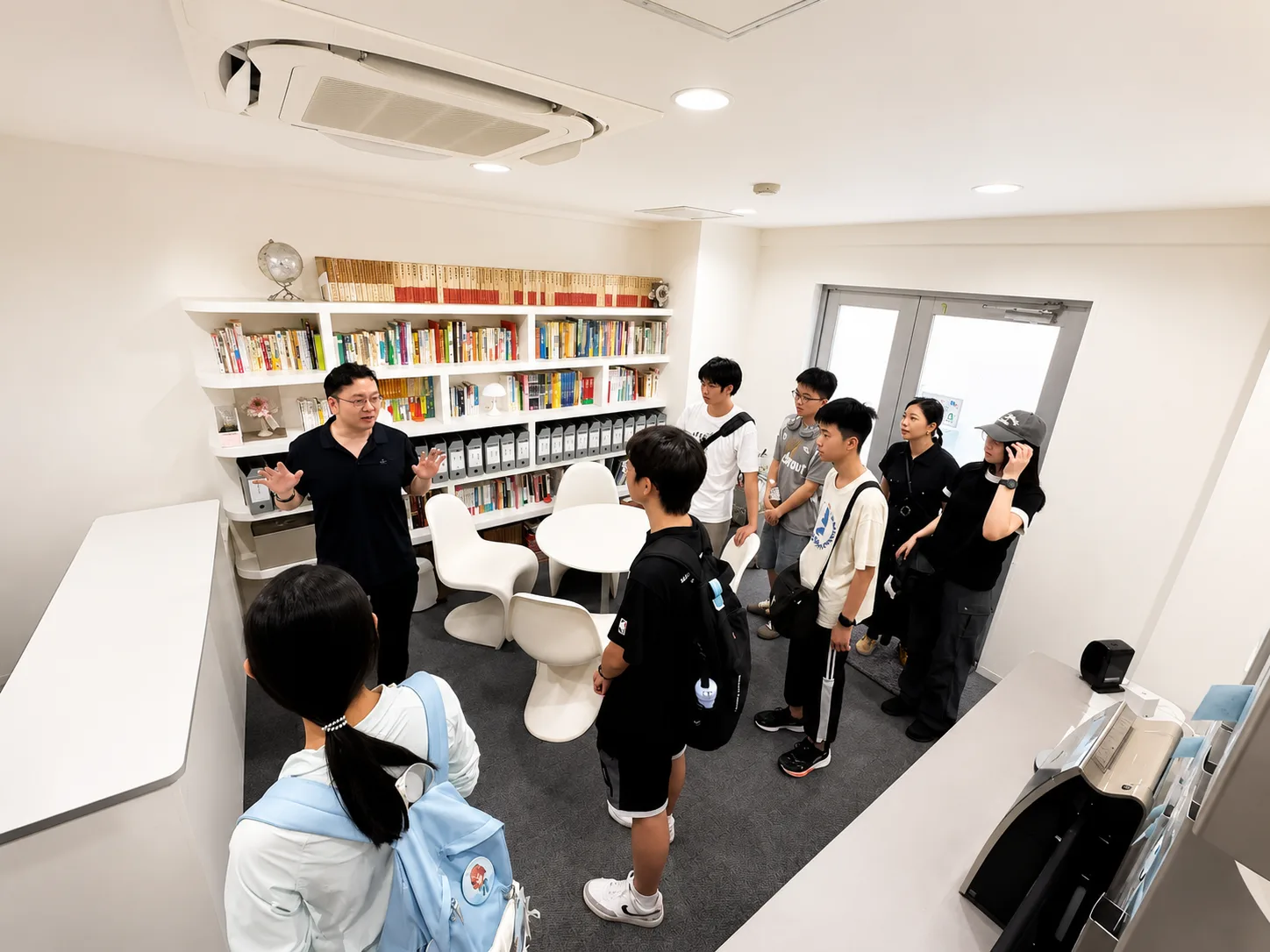 顾问在书墙前为学生进行升学咨询